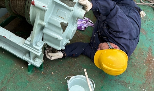 船上で整備作業を行う船員